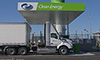 Photo of a large heavy-duty truck pulling into a charging station